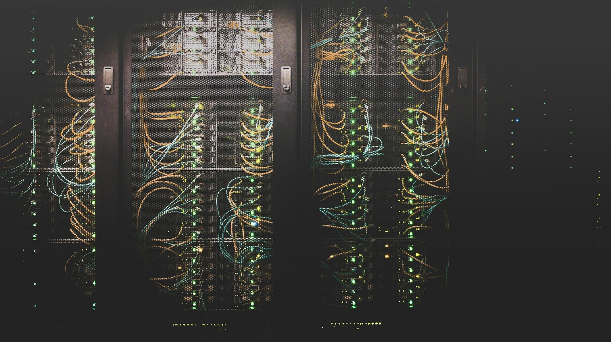 Cold aisle of a data centre lit in low blue light